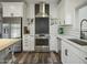 Bright kitchen features white cabinets, stainless steel appliances, subway tile backsplash, and dark wood-look flooring at 5110 E Peak View Rd, Cave Creek, AZ 85331