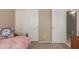 Bedroom with pink bedding and matching throw pillows, and sliding-door closet at 5432 N Ormondo Way, Litchfield Park, AZ 85340