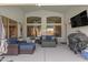 A well-appointed covered patio with comfortable seating and a TV, extending the living space outdoors for relaxation at 5432 N Ormondo Way, Litchfield Park, AZ 85340