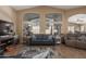 A bright and airy living room features a vaulted ceiling, large windows, and stylish decor creating a cozy atmosphere at 5432 N Ormondo Way, Litchfield Park, AZ 85340