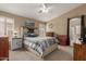 Cozy bedroom with ceiling fan, decorative headboard, and bright natural light at 5432 N Ormondo Way, Litchfield Park, AZ 85340