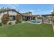 Expansive backyard featuring a pool, covered patio, verdant lawn, and climbing flowers on home exterior at 6102 E Calle Del Norte --, Scottsdale, AZ 85251