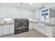 Well-lit laundry room featuring modern washer/dryer, white cabinets, and sleek countertops at 6102 E Calle Del Norte --, Scottsdale, AZ 85251