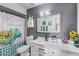 Well-lit bathroom with a shower, patterned curtain, modern vanity, and a large mirror at 6237 W Altadena Ave, Glendale, AZ 85304