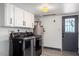 Bright laundry room with white cabinets, modern appliances, and access to the backyard at 6237 W Altadena Ave, Glendale, AZ 85304