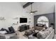 Cozy living room features a vaulted ceiling, ceiling fan, large TV, and comfortable seating at 6237 W Altadena Ave, Glendale, AZ 85304