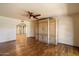 Bedroom with wood floors, ceiling fan, and a large built-in cabinet at 6252 E Aire Libre Ln, Scottsdale, AZ 85254