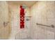 Tiled walk-in shower with a rain shower head, handheld wand, and multiple body jets on a red panel at 6252 E Aire Libre Ln, Scottsdale, AZ 85254