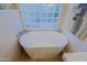The luxurious soaking tub has modern fixtures and is set below a glass block window at 6936 E Whispering Mesquite Trl, Scottsdale, AZ 85266