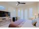 Spacious bedroom featuring shuttered doors to the outside, TV and bev cooler, and ceiling fan at 6936 E Whispering Mesquite Trl, Scottsdale, AZ 85266