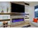 Close-up of a modern stone fireplace with an electric insert and built-in shelving at 6936 E Whispering Mesquite Trl, Scottsdale, AZ 85266