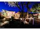 A beautifully lit home exterior at night with desert landscaping and a circular driveway at 6936 E Whispering Mesquite Trl, Scottsdale, AZ 85266