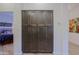 Hallway with large pantry featuring custom cabinets that leads to bedroom with stylish artwork at 6936 E Whispering Mesquite Trl, Scottsdale, AZ 85266