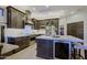 Modern kitchen with dark wood cabinetry, stainless steel appliances, island seating, and bright lighting at 6936 E Whispering Mesquite Trl, Scottsdale, AZ 85266