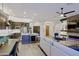 Open-concept living room and kitchen with modern finishes, stone fireplace, and ceiling fan at 6936 E Whispering Mesquite Trl, Scottsdale, AZ 85266