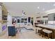 Bright, open-concept living space with a fireplace and eat-in kitchen area with an island and bar stools at 6936 E Whispering Mesquite Trl, Scottsdale, AZ 85266