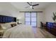 The large main bedroom features wood-style flooring, a ceiling fan, and dark wood furnishings at 6936 E Whispering Mesquite Trl, Scottsdale, AZ 85266