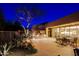 An outdoor kitchen and patio area with a built-in grill, dining set, and desert landscaping at 6936 E Whispering Mesquite Trl, Scottsdale, AZ 85266
