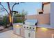 Outdoor kitchen with a built-in grill, counter space and stainless steel storage at 6936 E Whispering Mesquite Trl, Scottsdale, AZ 85266