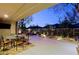 Evening view of covered patio featuring ample seating, manicured desert landscaping, and scenic views at 6936 E Whispering Mesquite Trl, Scottsdale, AZ 85266