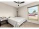 Bright bedroom with a queen bed, ceiling fan, and a large window overlooking the exterior at 806 W El Alba Way, Chandler, AZ 85225