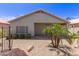 Back of home featuring a covered patio, desert landscaping, and stone facade at 9032 W Sierra Pinta Dr, Peoria, AZ 85382