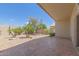 Landscaped backyard featuring a stone patio, desert plants, and clear blue skies at 9032 W Sierra Pinta Dr, Peoria, AZ 85382