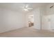 Bright bedroom with carpet flooring, a ceiling fan, and open access to a bathroom at 9032 W Sierra Pinta Dr, Peoria, AZ 85382