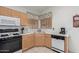 A bright kitchen featuring tile floors, wood cabinets, white countertops, a stove, a microwave, and a sink at 9032 W Sierra Pinta Dr, Peoria, AZ 85382