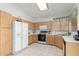 Bright kitchen features tile floors, a skylight, and wooden cabinets with white countertops and appliances at 9032 W Sierra Pinta Dr, Peoria, AZ 85382
