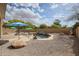 Serene backyard featuring a rock-lined pool, desert landscaping, and shady umbrellas for outdoor relaxation and enjoyment at 9698 S 183Rd Ave, Goodyear, AZ 85338