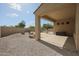 View of the gravel backyard and covered patio, surrounded by privacy walls and desert plants at 9698 S 183Rd Ave, Goodyear, AZ 85338