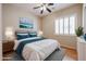Bedroom features queen size bed, ceiling fan, accent wall art, and bright window at 9698 S 183Rd Ave, Goodyear, AZ 85338