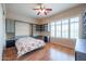 Bedroom featuring a Murphy bed, wood floors, window shutters, and custom shelving at 9698 S 183Rd Ave, Goodyear, AZ 85338