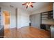 Bedroom featuring a Murphy bed, wood floors, window shutters, and custom shelving at 9698 S 183Rd Ave, Goodyear, AZ 85338