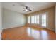 Bedroom with laminate flooring, shuttered windows, ceiling fan, and neutral color paint at 9698 S 183Rd Ave, Goodyear, AZ 85338