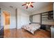 Bedroom featuring a Murphy bed, wood floors, window shutters, and custom shelving at 9698 S 183Rd Ave, Goodyear, AZ 85338