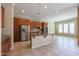 Modern kitchen with stainless steel refrigerator, wood cabinets, granite counters and tiled floors at 9698 S 183Rd Ave, Goodyear, AZ 85338