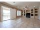 Spacious living room with tile flooring, built in shelves, and sliding glass doors to the backyard at 9698 S 183Rd Ave, Goodyear, AZ 85338