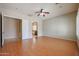Spacious main bedroom features wood floors, ceiling fan, and entry to bathroom and walk-in closet at 9698 S 183Rd Ave, Goodyear, AZ 85338
