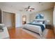 Well-staged main bedroom features laminate floors, ceiling fan, and a view into the bathroom at 9698 S 183Rd Ave, Goodyear, AZ 85338
