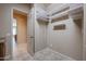 Walk-in closet with custom shelving and tile flooring with hallway view at 9698 S 183Rd Ave, Goodyear, AZ 85338