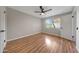 Comfortable bedroom featuring hardwood floors and a bright window with outside view at 10713 W Santa Fe Dr, Sun City, AZ 85351