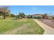 Attractive front yard landscaping, lush lawns, mature trees, and sidewalk at 10713 W Santa Fe Dr, Sun City, AZ 85351
