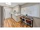Kitchen featuring ample natural light, wood flooring, and a charming breakfast bar with seating at 10713 W Santa Fe Dr, Sun City, AZ 85351