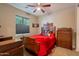 Bedroom featuring window, bed with red comforter and dresser at 10846 E Quartet Ave, Mesa, AZ 85212