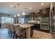 Well-equipped kitchen featuring dark cabinetry, granite countertops, stainless steel appliances, and a large island at 10846 E Quartet Ave, Mesa, AZ 85212