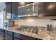 Gourmet kitchen with stainless gas range, granite countertops and brown cabinets at 10846 E Quartet Ave, Mesa, AZ 85212