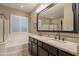 Bathroom featuring double sinks, large mirror, tub and walk-in shower at 10846 E Quartet Ave, Mesa, AZ 85212