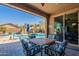 Covered patio with outdoor seating overlooking the pool area, perfect for outdoor entertaining and relaxation at 10846 E Quartet Ave, Mesa, AZ 85212